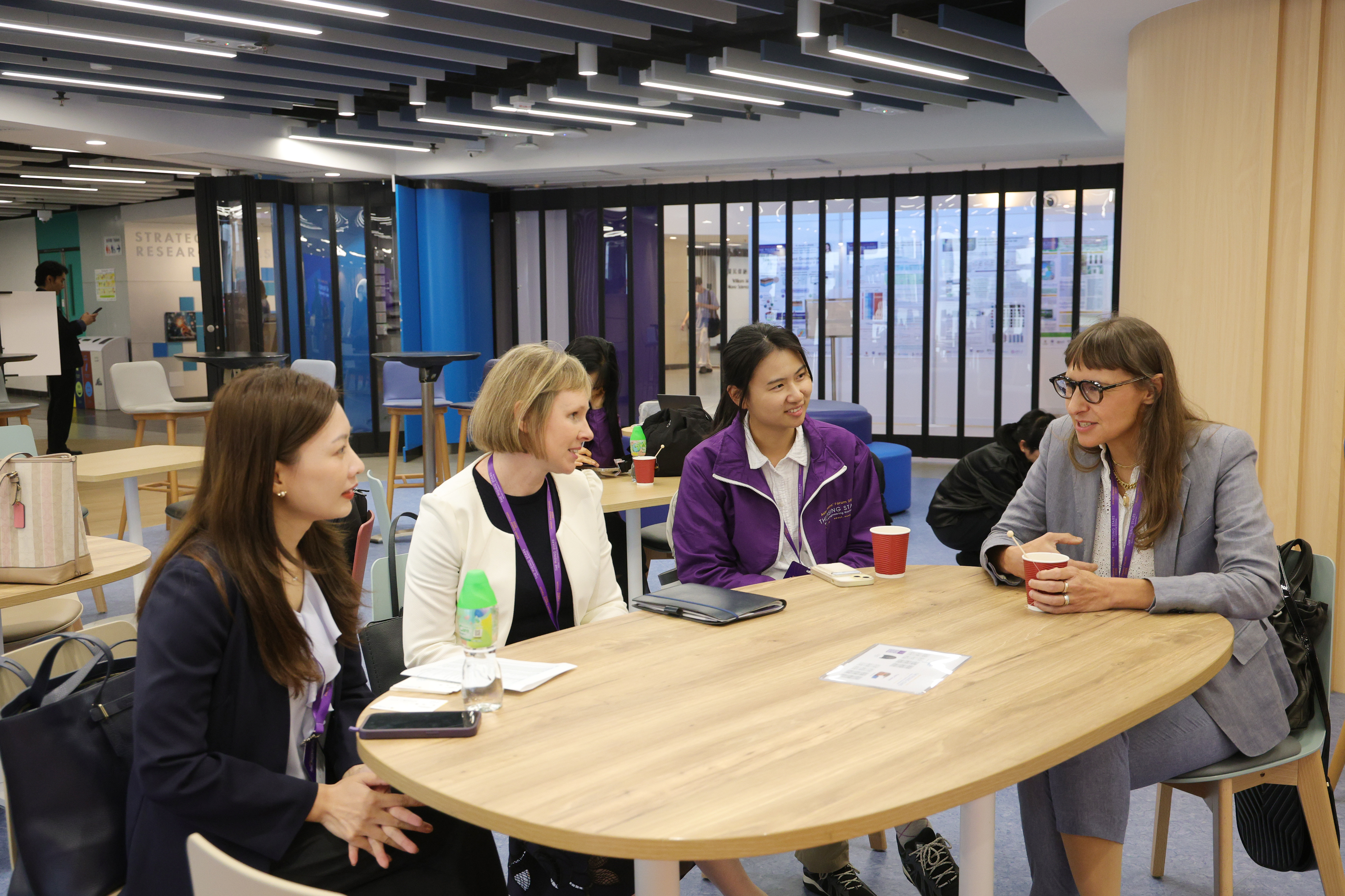 Workshop participants and faculty talking around a table during a break.